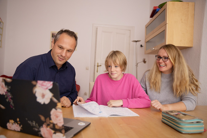 Mutter & Vater besprechen Schulaufgaben mit Tochter